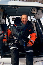 Cameraman, Doug Allan, sitting on the open door of a helicopter used for filming in the Arctic for the BBC Ray Mears series Heroes of Telemark, 2003.