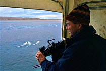 Cameraman Doug Allan in hide filming Beluga whales (Delphinapterus leucas) in estuary mouth, Cunningham inlet, Somerset Island, Canadian Arctic, July 2000