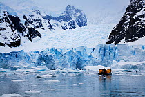 Tourists in inflatable boat cruising along the front of Petzval glacier, Skontrop Cove, Paradise Bay, Antarctica, November 2008