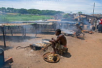 Frying and drying Cichlid fish "Utaka" (Copadichromis sp) a species endemic to Lake Malawi, Malawi. March 2009