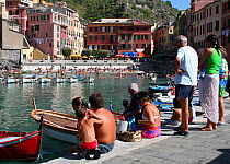 Families relaxing in the sunshine around the harbour at Vernazza, Cinque Terre, Italy, 2006.