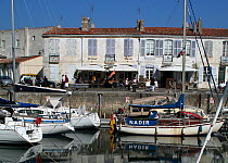 Sailing-boats moored in the marina at Saint-Martin-de-Re, busy quayside behind, Ile de Re, France, 2007.