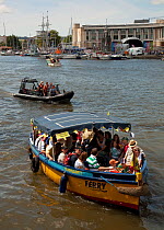 Passenger ferry on the harbour during Bristol's 2009 Harbour Festival, with music stage in the background, England, UK, 2009.