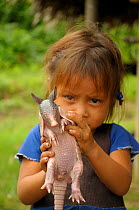 Peruvian girl holding Nine banded armadilo (Dasypus novemcinctus) Peru