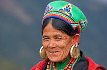 Portrait of smiling woman with earings. Tamang ethnic group, Tamang heritage trail, Naghtali, Langtang region, Nepal. November 2009