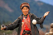 Woman spinning wool on a spindle. Tamang ethnic group, Tamang heritage trail, Naghtali, Langtang region, Nepal. November 2009