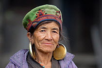 Head portrait of elderly woman with large earrings. Tamang ethnic group, Tamang heritage trail, Thuman, Langtang region, Nepal., November 2009