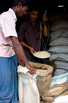 Rice trader weighing rice, Bangladesh,  October 2008