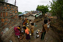 People collecting clean water from tap in industrial slum, Bhopal, Madhya Pradesh, India, November 2008