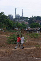 Men walking through industrial slum, Bhopal, Madhya Pradesh, India, November 2008