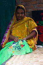 Woman embroidering cloth, part of a craft scheme to alleviate rural poverty, Ganges delta, Bangladesh, October 2008