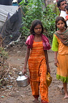 Girl collecting clean water in industrial slum, Bhopal, Madhya Pradesh, India, November 2008