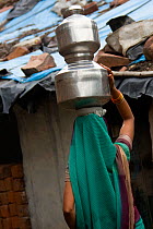 woman collecting clean water in industrial slum, Bhopal, Madhya Pradesh, India, November 2008