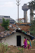 Family entering house in industrial slum, Bhopal, Madhya Pradesh, India, November 2008