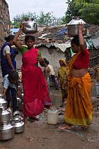 Women and children collecting clean water in industrial slum Bhopal Madyah Pradesh, India, November 2008