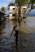 Fresh water pump and house surrounded by flood from rising sea levels, Passur river, Ganges delta, Bangladesh, June 2008
