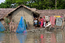 Family with their home threatened by rising sea level, Ganges delta, Bangladesh, July 2008