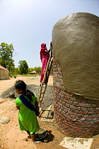 Women building tourist Rondavel / Lodge in forest for Tiger tourism, near Bandhavgah NP, Madhya Pradesh, India, November 2008