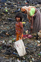 Adult and child searching for recyclable objects in landfill site, Dhaka, Bangladesh, November 2008