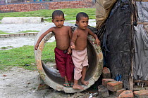 Children playing in drainage pipe in slum, Dhaka, Bangladesh, November 2008, November 2008