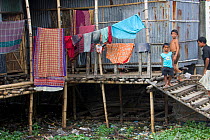 Children in slum housing over polluted water, Dhaka, Bangladesh, November 2008