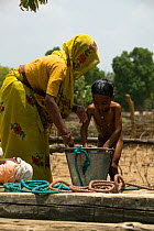 Hindu woman washing son at well, village life, Madyha Pradesh,  India, Asia, November 2008