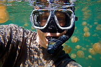 Diver working underwater amongst mass of Mastigias jellyfish (Mastigias sp) in Jellyfish lake, Palau, Western Pacific Islands, Micronesia, March 2009
