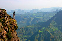 Wildlife biologist, Dr. Chadden Hunter, standing at the top of a 300 metre sheer drop scouting the cliffs of the Simien Mountains looking for the Walia Ibex mountain goat, for the Mountains episode of...
