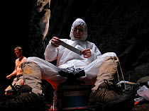 Cameraman, Chadden Hunter, taping up rip in his paper suit meant to keep out the millions of cockroaches and centipedes living on bat guano covering the cave floor, for the Caves episode of the BBC tv...