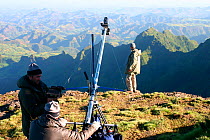 Chadden Hunter (scientific consultant), directs the camera into position as the team use a jib arm to swing the HD camera out over a 300 metre sheer drop in the Simien Mountains NP, Ethiopia,  to film...