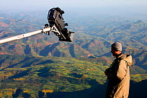 Scientific consultant, Chadden Hunter, directing the camera into position as the team use a jib arm to swing the HD camera out over a 300 metre sheer drop in the Simien Mountains to film the rare Wali...