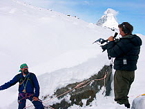 Cameraman, Chadden Hunter, filming rope safety expert, Tono De Vivo, describing the dangers of descending into the glacial ice caves moulins', the ice caves that drain meltwater through glaciers, Gor...