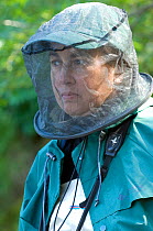 Woman tourist wearing Mosquito net over her head to keep off biting insects, Small Xedutka River, Kamchatka Wilderness, Russia, August 2006