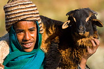Local woman with goat, wearing traditional hat, Simien Mountains NP, Ethiopia