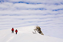 People walking down a snow slope to Windy Ridge, with altocumulus undulatus clouds above them. Patriot Hills. West Antarctica, January 2006.