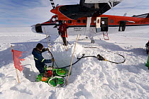 Refuelling a Twin Otter at Theal from a buried fuel cache on the way to the South Pole. Antarctica, January 2006.