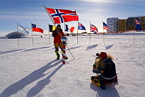 Members of the Norwegian Ski Expedition,'Living the Dream', pose by the reflecting globe at the Ceremonial Pole. South Pole, Antarctica, January 2006.