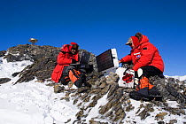 Scientists set up a GPS receiver to collect data as part of the WAGN (West Antarctic GPS Network) Project, which measures movement of land & ice. Patriot Hills. Antarctica, January 2006.