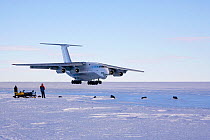 Ilyushin 76 approaching the Blue Ice Runway as it lands at Patriot Hills, people in the foreground. Antarctica, January 2006.