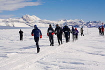 Runners competing in the 2006 Antarctic Ice Marathon pass the start banner. Patriot Hills, Antarctica, January 2006.