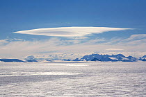 Stratocumulus cloud formation hanging over the Ellsworth Mountains while a higher stratus formation is backlit over the Polar Plateau, Antarctica, January 2006.