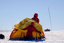People putting up a mountain tent in a high wind. Patriot Hills, Antarctica, January 2006.