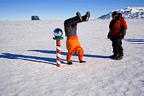 Celebratory hand walk around the Ceremonial South Pole. Antarctica, January 2006.