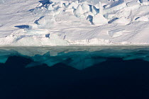 Edge of sea ice showing the reflection of the ice above and also the blue of the submerged ice. Antarctica, October 2006.