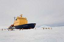 Russian icebreaker "Kapitan Khlebnikov" parked in the sea ice with tourists walking close by. Antarctica, October 2006.