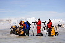 Photographers, both amateur and professional, photographing Emperor penguins (Aptenodytes forsteri), Antarctica, October 2006.