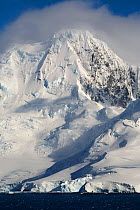 Cloud topped mountain and katabatic winds in the lower glaciers. The Gerlache Strait, Southern Ocean, Antarctica, October 2006.