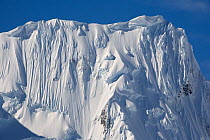 Dramatic cornices top a mountain peak covered with ice and glaciers. Gerlache Strait, Antarctica, October 2006.