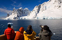 Tourists on the flying bridge as they pass through the Lemaire Channel, Southern Ocean, Antarctica, October 2006.