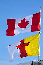 Canadian national flag and the Flag of Nunavut flying together. Canada, April 2008.